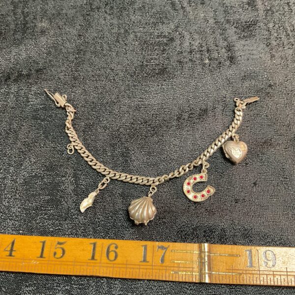 Vintage silver charm bracelet with five unique charms.