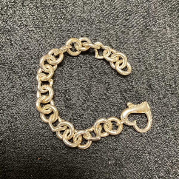 Close-up of a silver chunky heart link bracelet.
