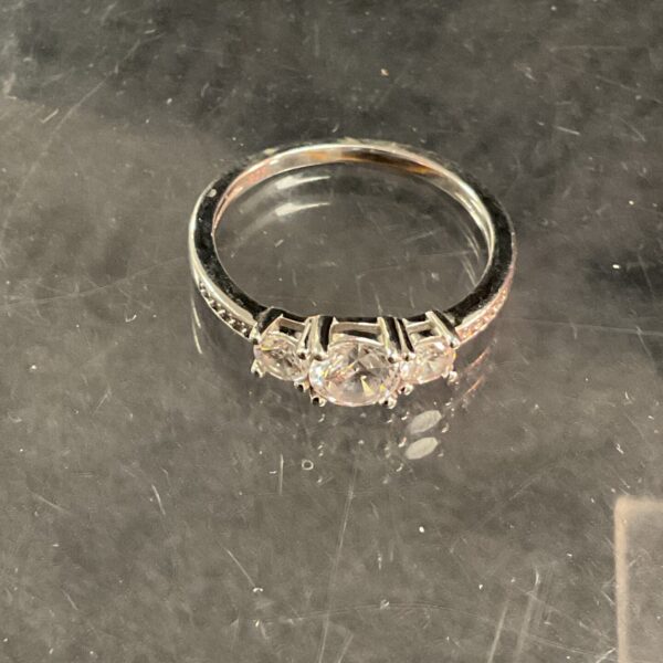 Silver ring with three cubic zirconia stones, size T.