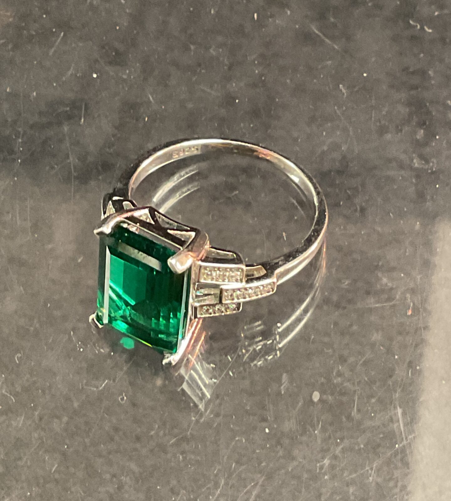 Silver ring with a large green stone, a stylish fashion accessory.
