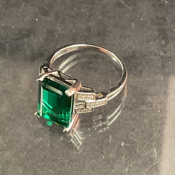 Silver ring with a large green stone, a stylish fashion accessory.