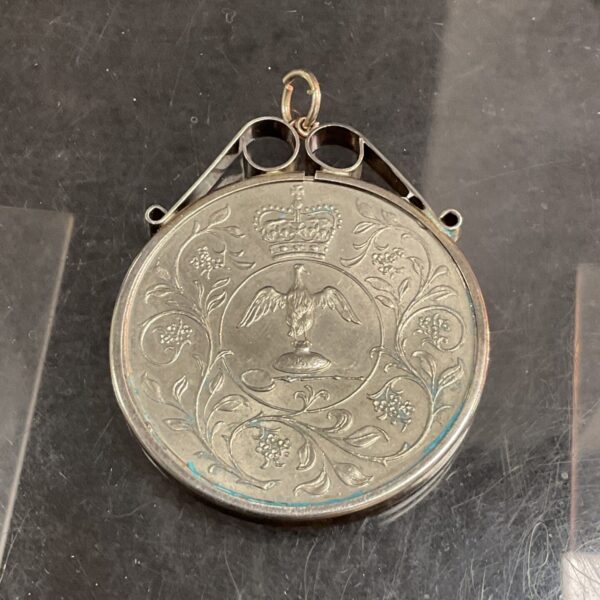 Intricate silver Jubilee coin mount with eagle design.