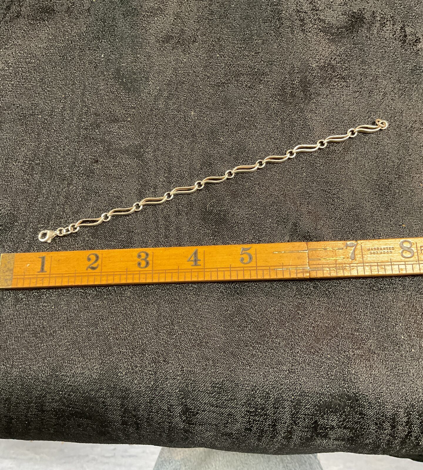 Close-up of a delicate silver leaf link bracelet.