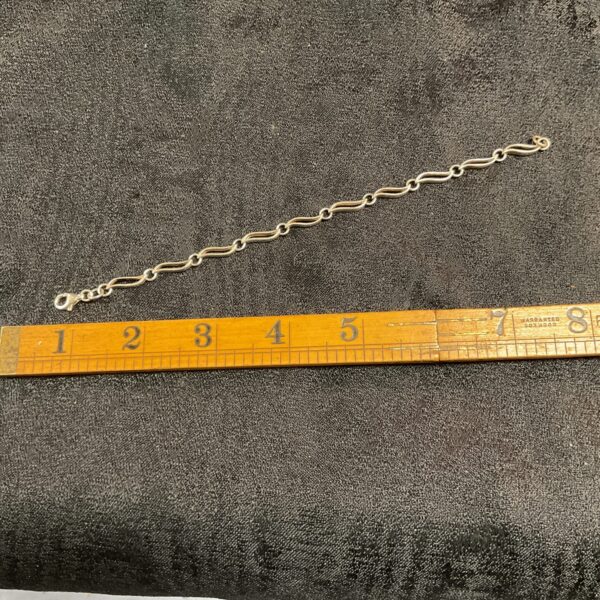 Close-up of a delicate silver leaf link bracelet.