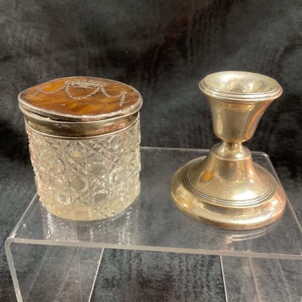 Antique silver and tortoise shell pot with candlestick on display.