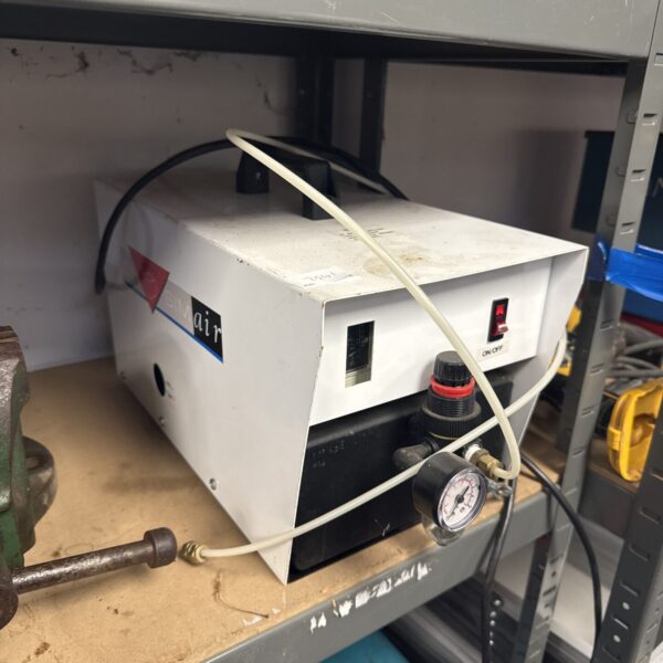 Front view of a Simair portable air compressor with pressure gauge.
