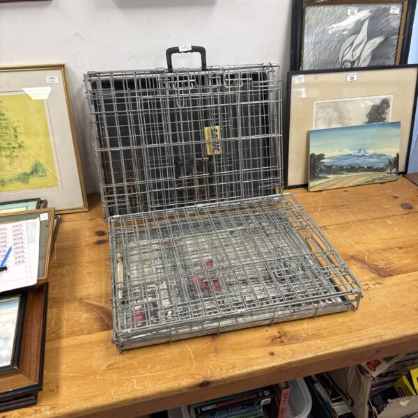 Two small metal dog cages for pet transport.