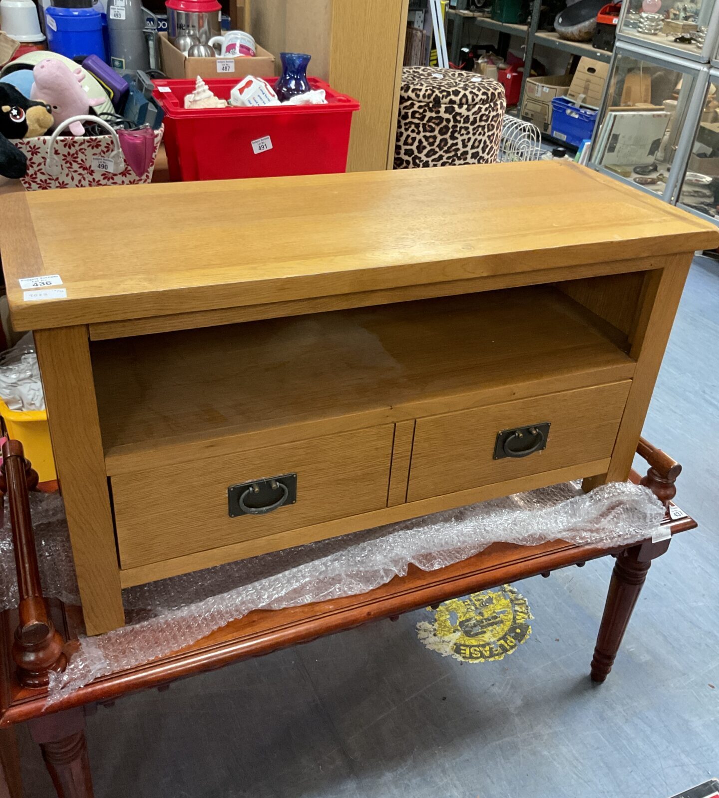 Small oak media cabinet with a single drawer and open shelf.