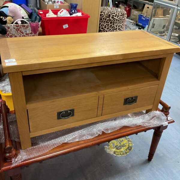 Small oak media cabinet with a single drawer and open shelf.