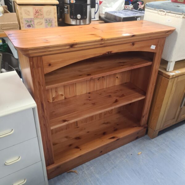 Small pine bookcase with three shelves, rustic wooden storage.