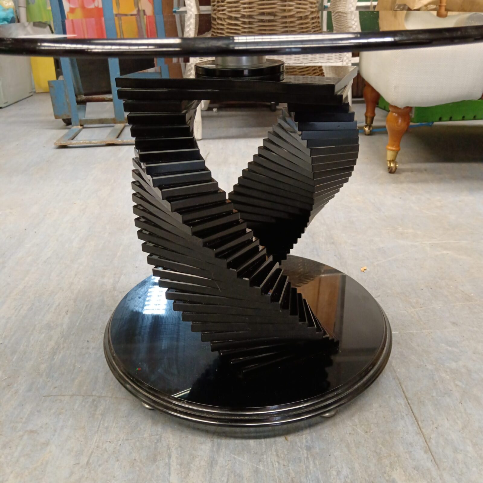 Close-up of black helix base on smoked glass table.