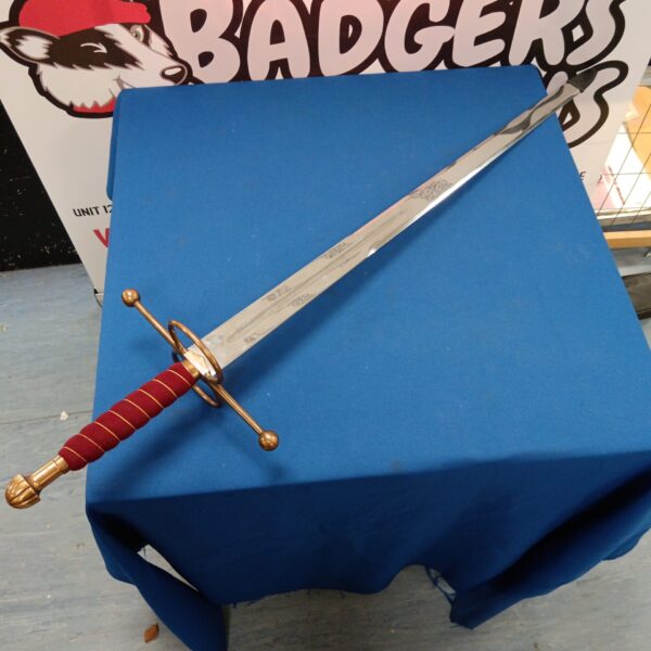 Antique Spanish ceremonial broadsword with copper hilt on display.