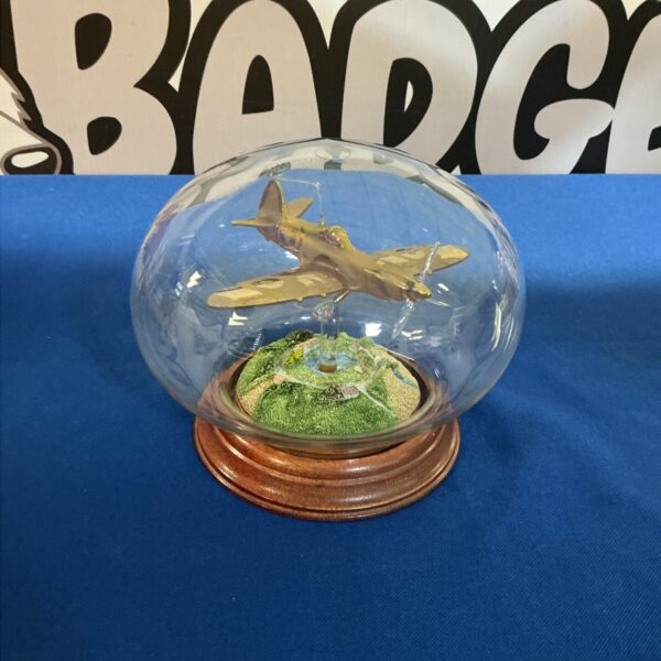 Detailed Spitfire model displayed in a glass dome on a wooden base.