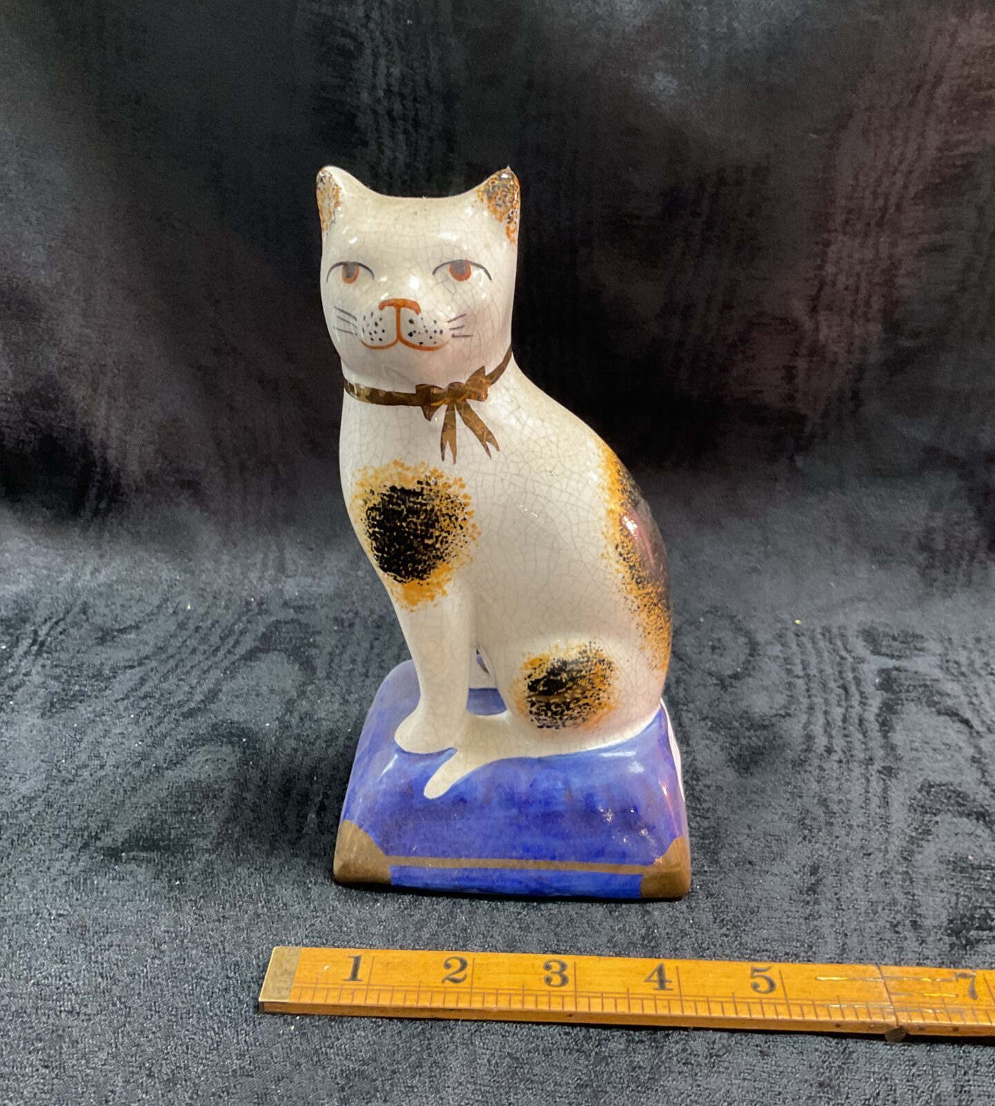 Vintage Staffordshire pottery cat figurine with calico pattern.
