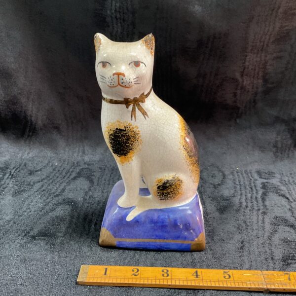 Vintage Staffordshire pottery cat figurine with calico pattern.
