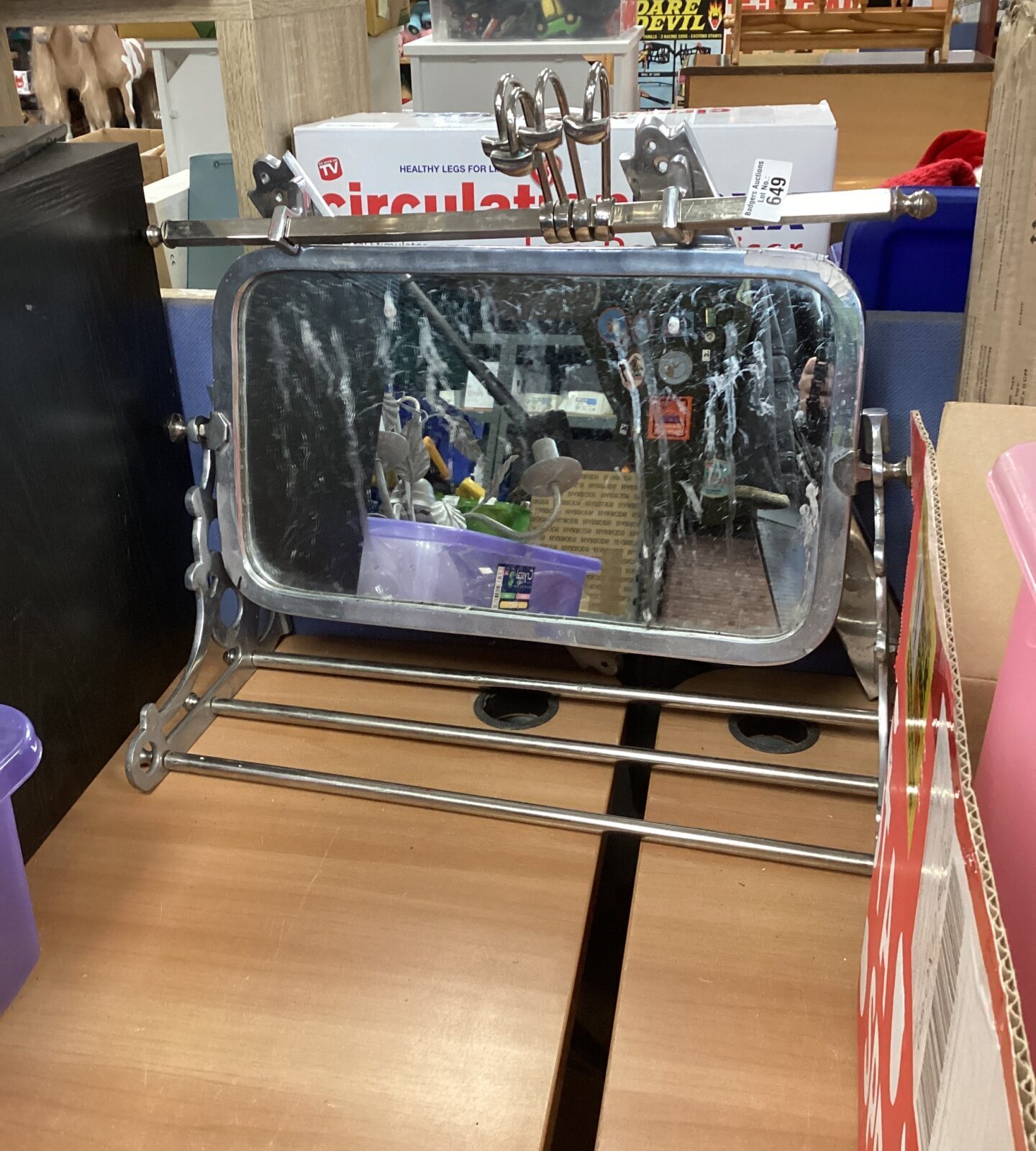 Vintage stainless steel mirror with integrated hangers for wall display.