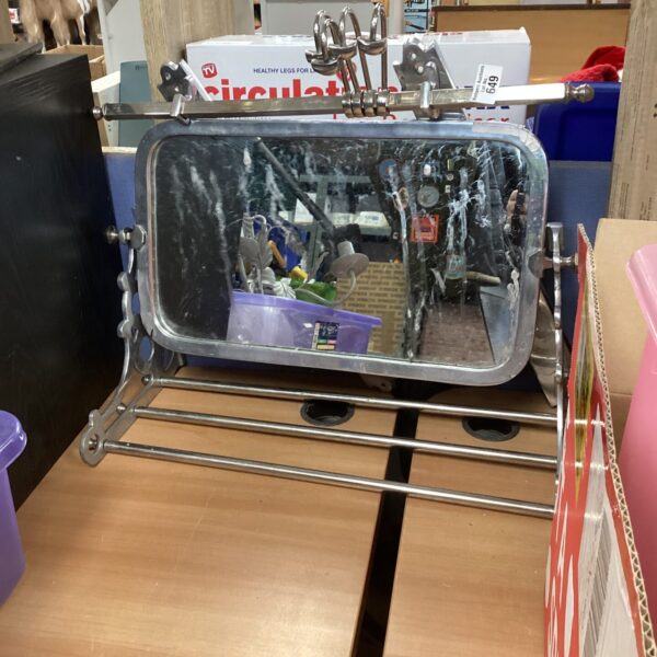 Vintage stainless steel mirror with integrated hangers for wall display.