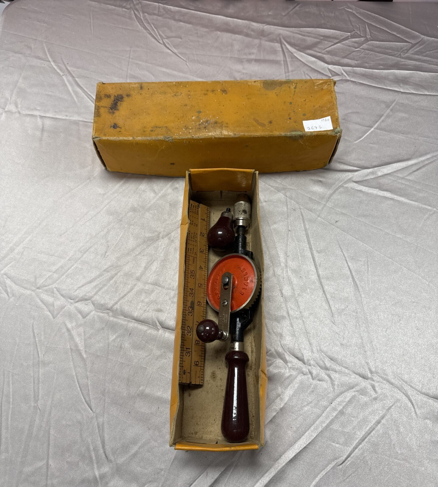 Vintage Stanley hand drill with Rabone wooden ruler for woodworking.