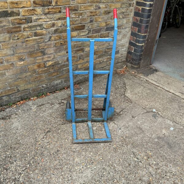 Steel sack barrow in a garden setting, ready for use.