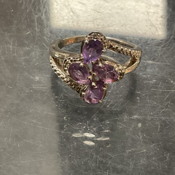 Close-up of a sterling silver amethyst ring with a square cut stone.