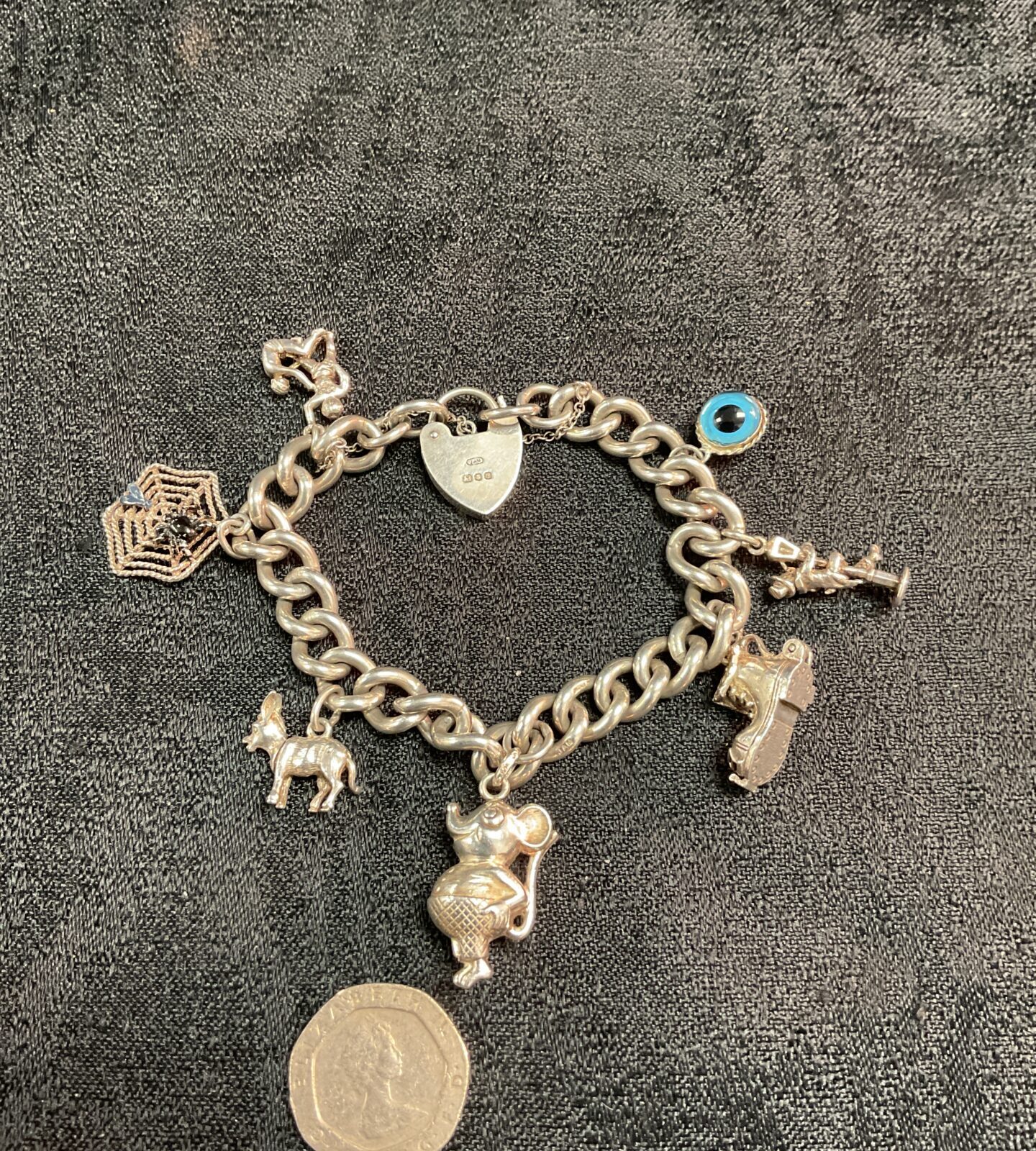 Vintage sterling silver charm bracelet with seven charms.