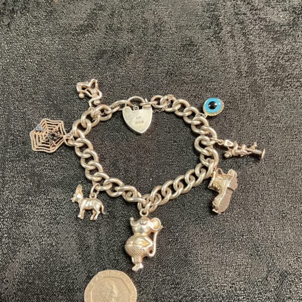 Vintage sterling silver charm bracelet with seven charms.