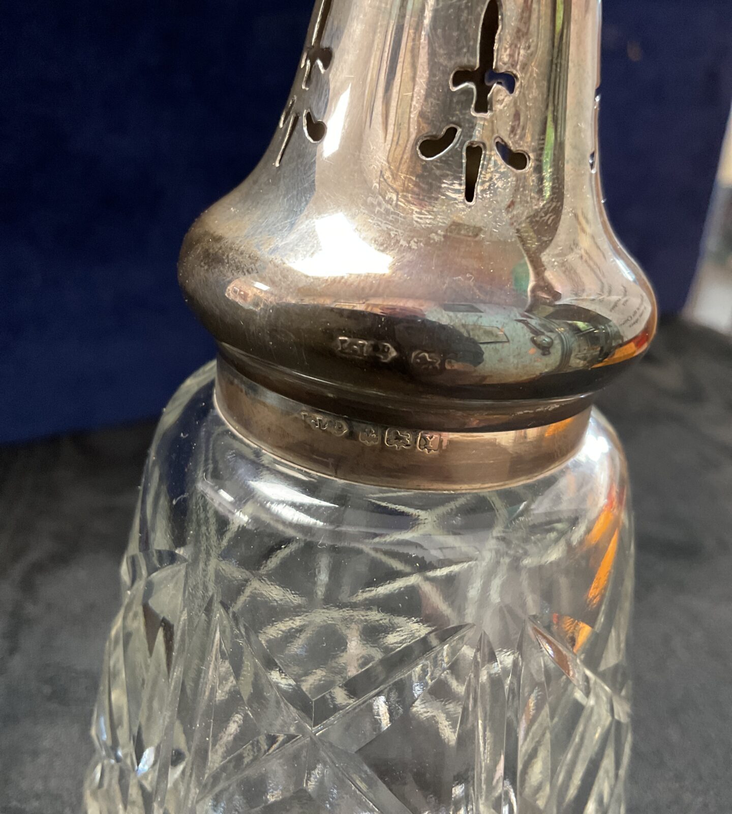 Close-up of antique sterling silver sifter hallmarks.