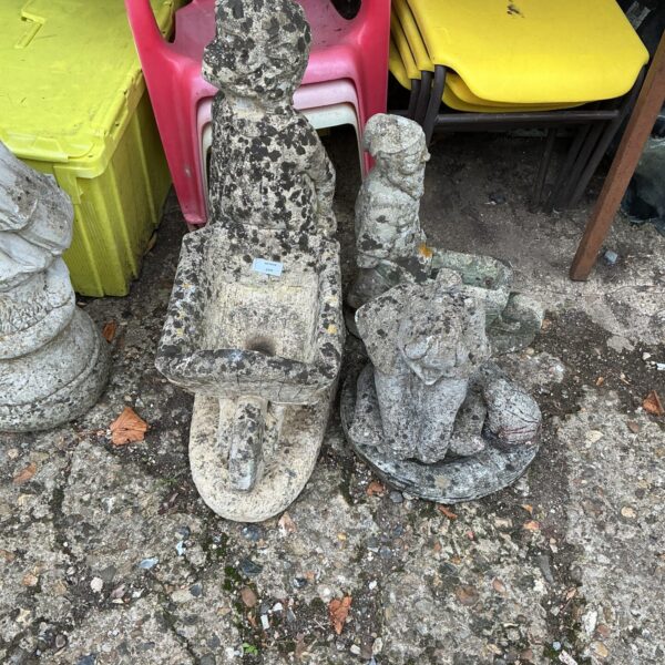 Charming stone garden ornament of a boy with a bird.