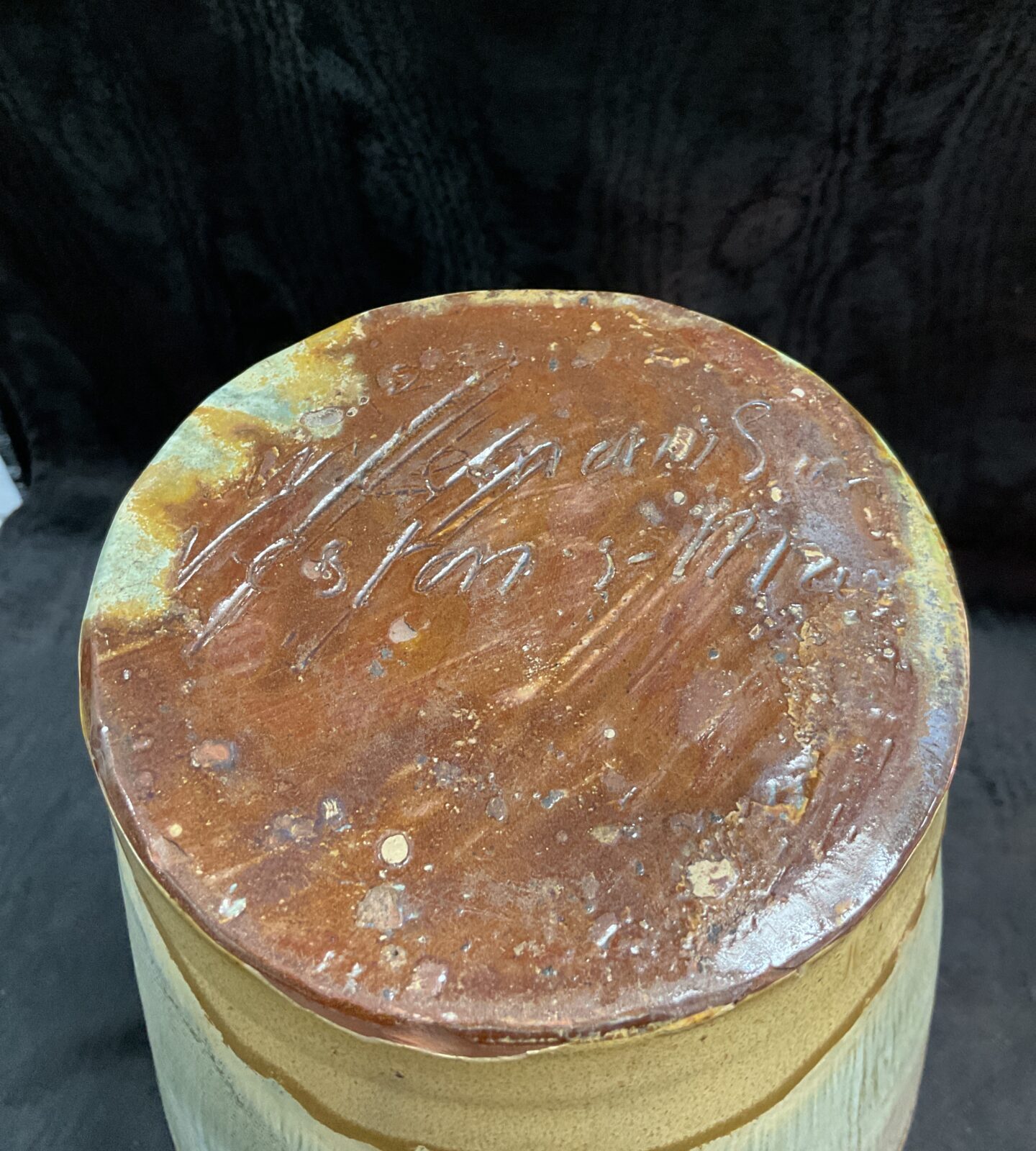 Side view of vintage studio pottery vase with embossed floral pattern.