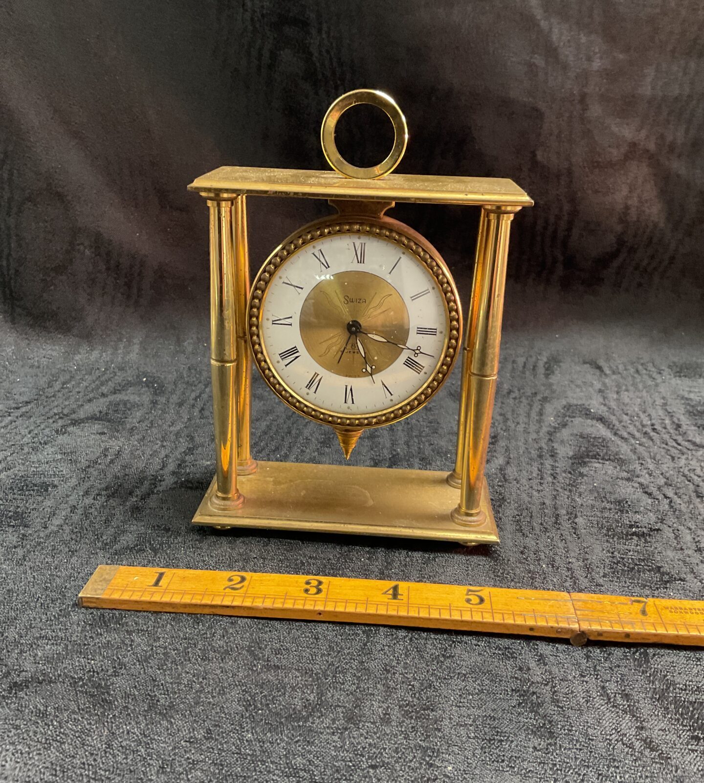 Vintage Swiza brass mantle clock with white dial.
