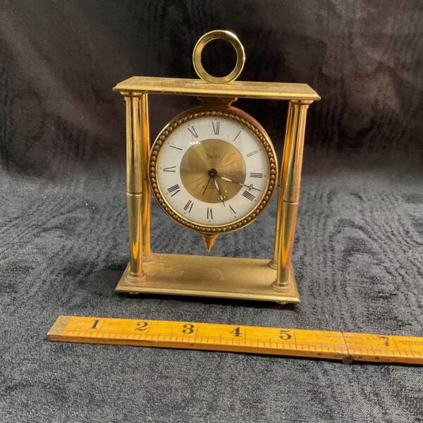 Vintage Swiza brass mantle clock with white dial.