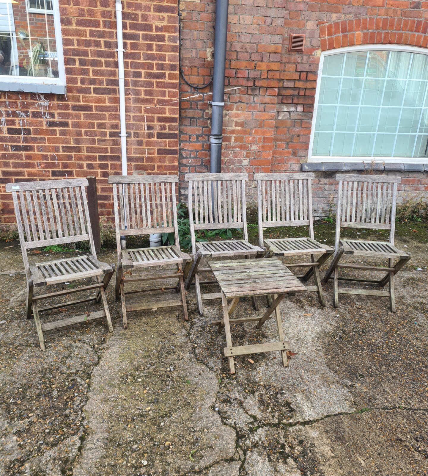 Five vintage teak garden folding chairs in a garden setting.