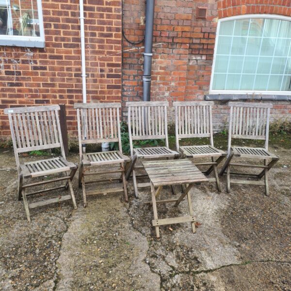 Five vintage teak garden folding chairs in a garden setting.