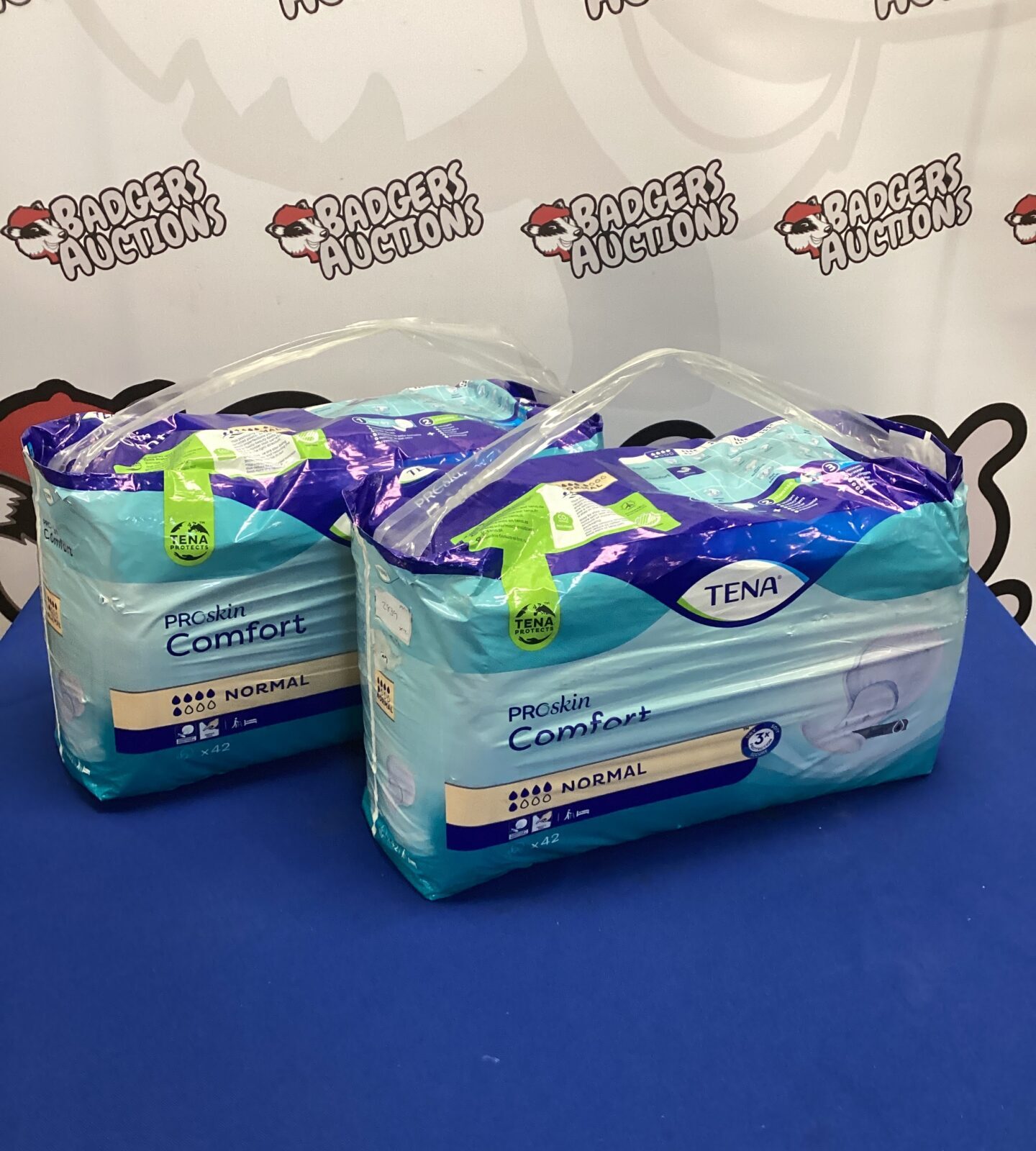 Sealed packs of Tena Pro Skin Comfort Pads for incontinence.