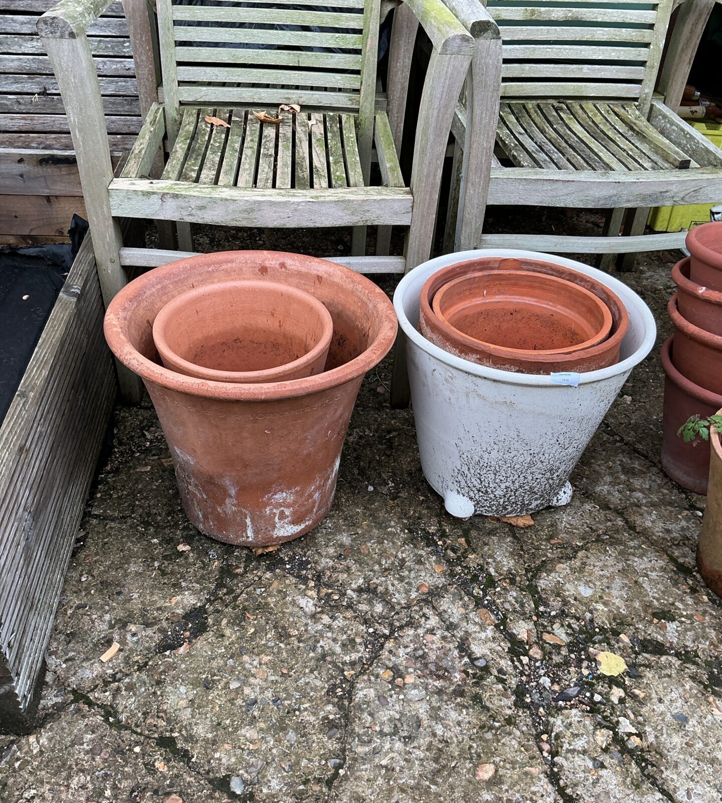 Lot of four weathered terracotta garden pots for outdoor plants.