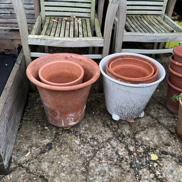 Lot of four weathered terracotta garden pots for outdoor plants.