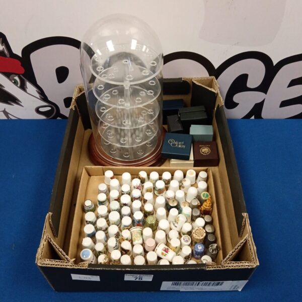 Vintage thimble collection displayed in a clear acrylic case.