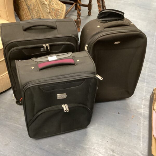 Dark coloured wheeled suitcases with extendable handles, travel luggage set.