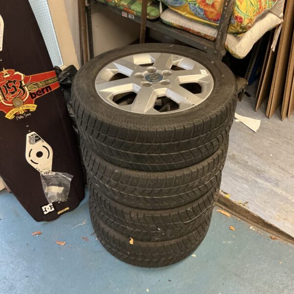 Stack of four used Vauxhall alloy wheels for sale.