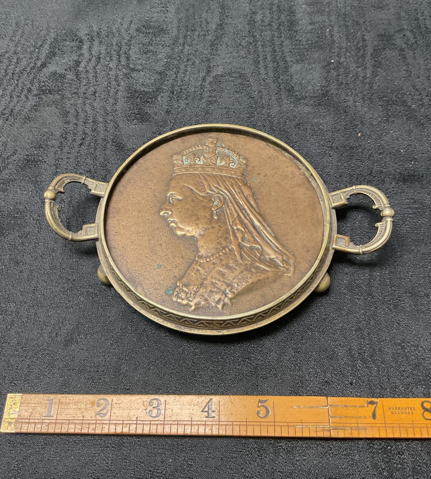 Antique Victorian brass trivet with Queen Victoria’s Diamond Jubilee head.