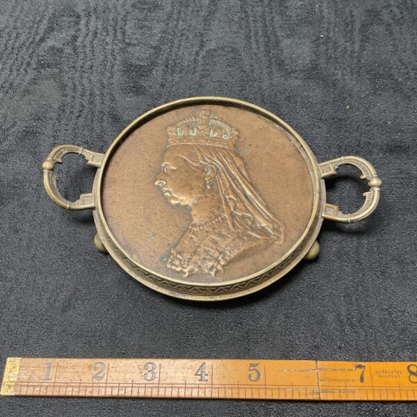 Antique Victorian brass trivet with Queen Victoria’s Diamond Jubilee head.