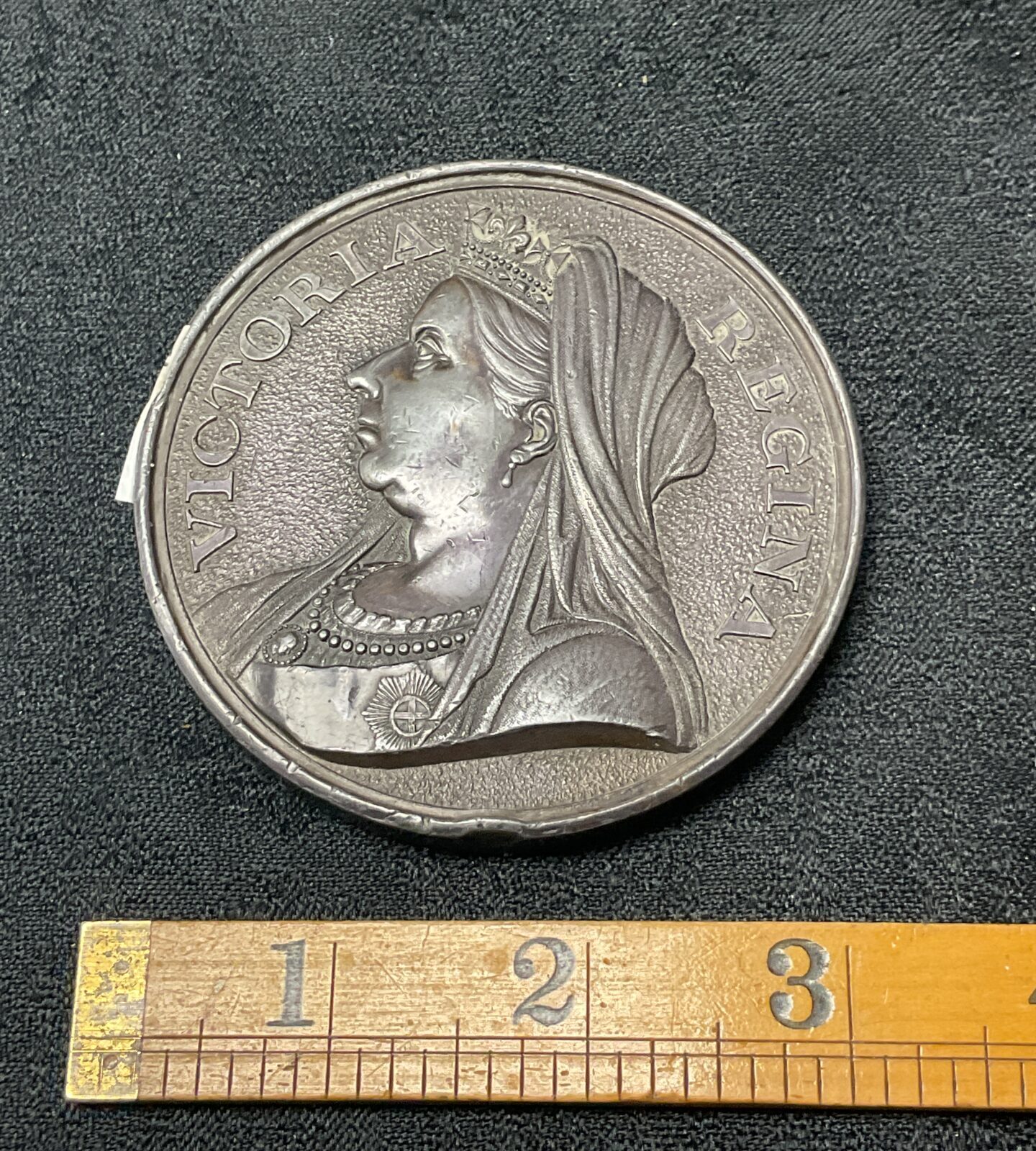 Antique pewter medal featuring Queen Victoria’s profile portrait.