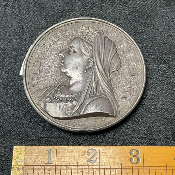 Antique pewter medal featuring Queen Victoria’s profile portrait.