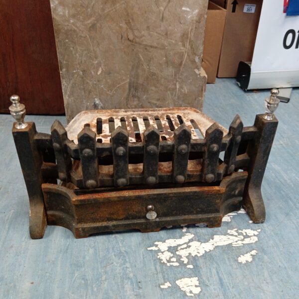 Antique Victorian cast iron fireplace grate with decorative bars.