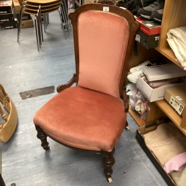 Antique Victorian nursing chair with mahogany frame and upholstered seat.