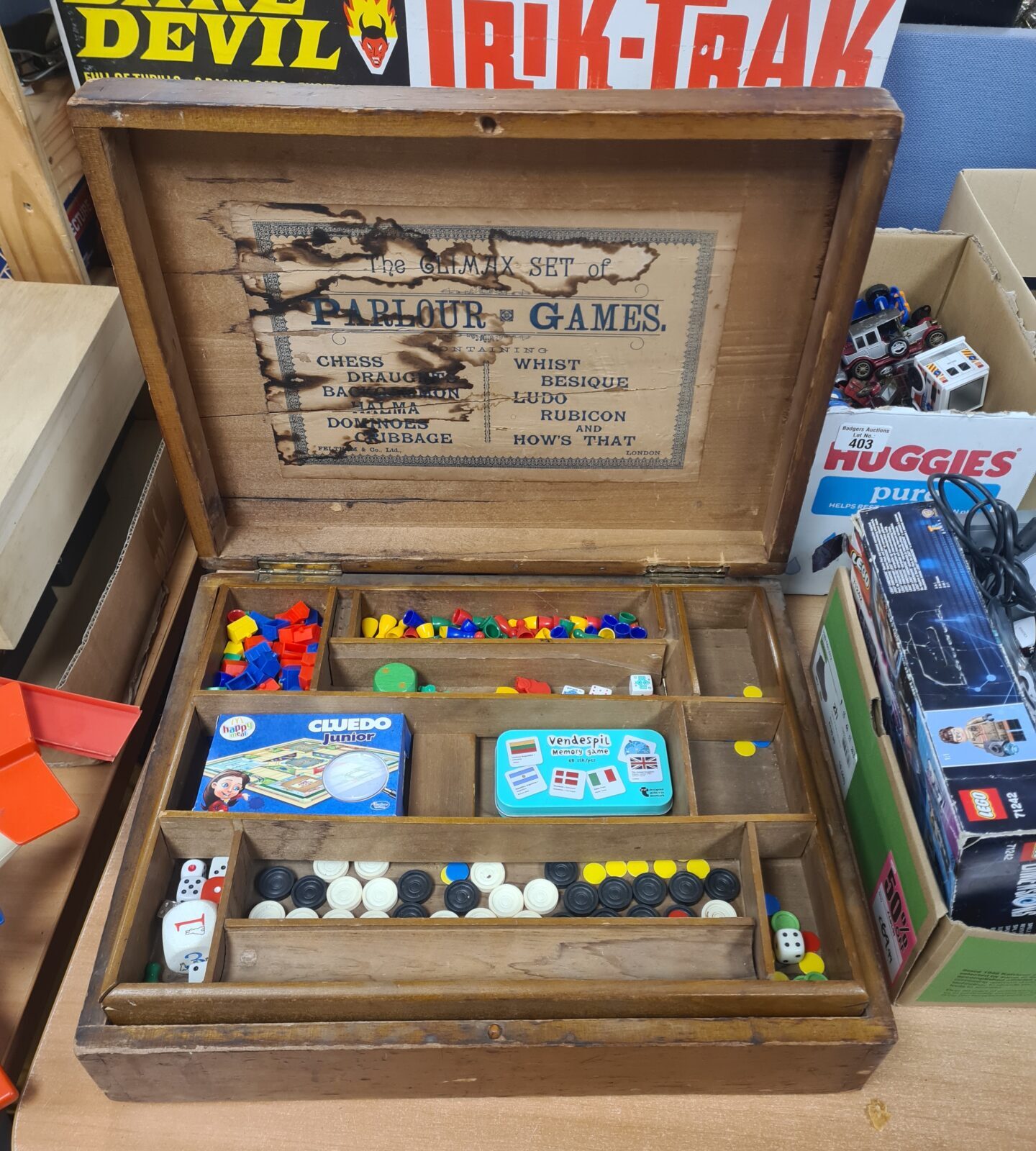 Victorian parlour games box open, showing a variety of colourful game pieces.