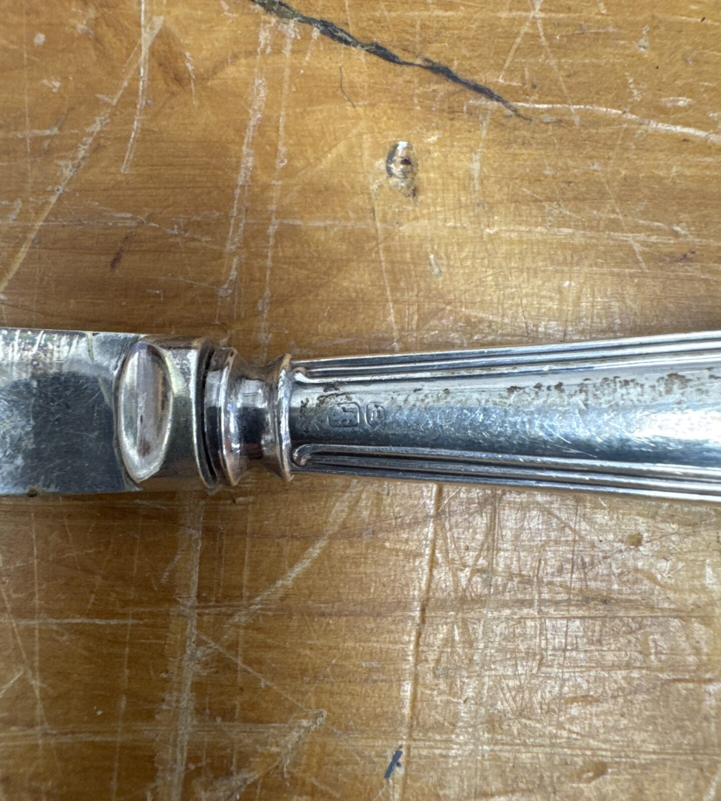 Close-up of a Victorian silver cake knife handle with floral detail.