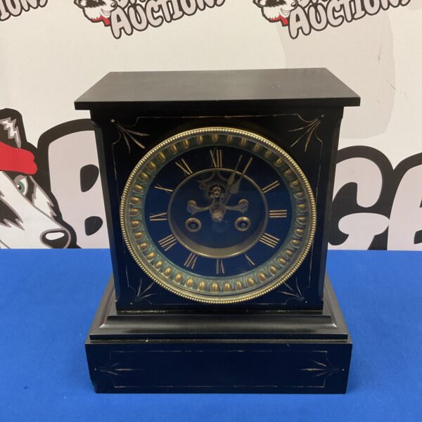 Front view of a Victorian slate mantle clock with brass face.