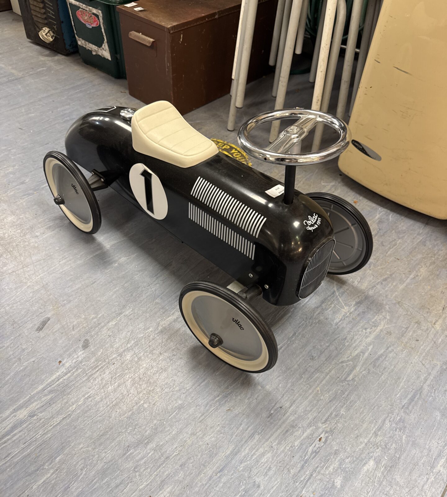 Vintage Vilac ride-on car in black with white wheels.