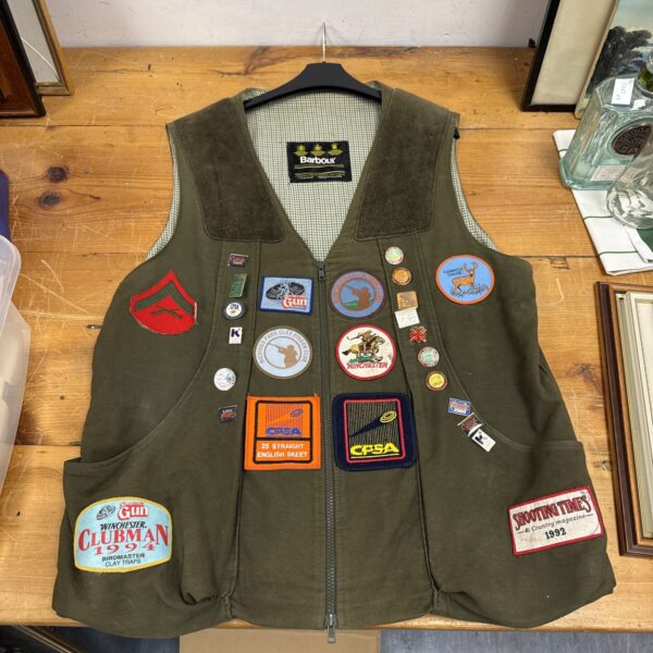 Vintage Barbour shooting gilet with colourful enamel badges.